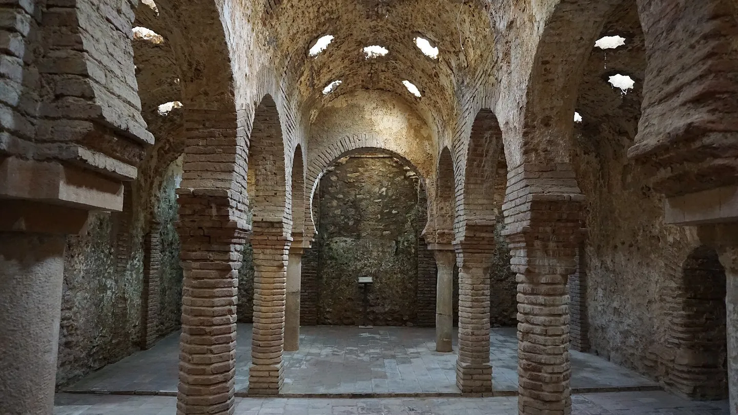 Sala central dos banhos árabes de Ronda, com arcos de ferradura sobre colunas de tijolo e claraboias em forma de estrela na abóbada