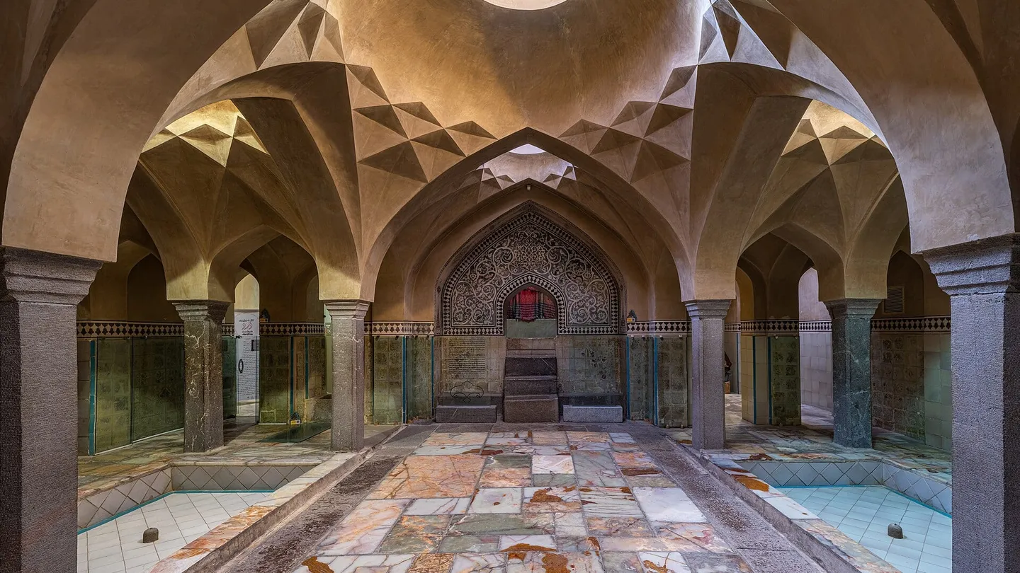 Salão abobadado do hammam Ali Gholi Agha, em Isfahan, com colunas de pedra, arcos e claraboia no centro