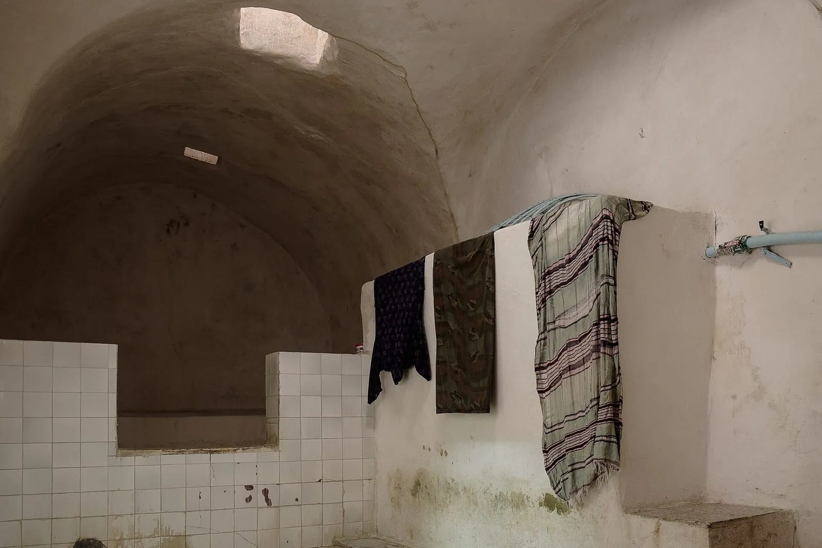Caldarium do hammam Zeitouni, em Túnis, com paredes brancas, nichos abobadados e uma tina de pedra