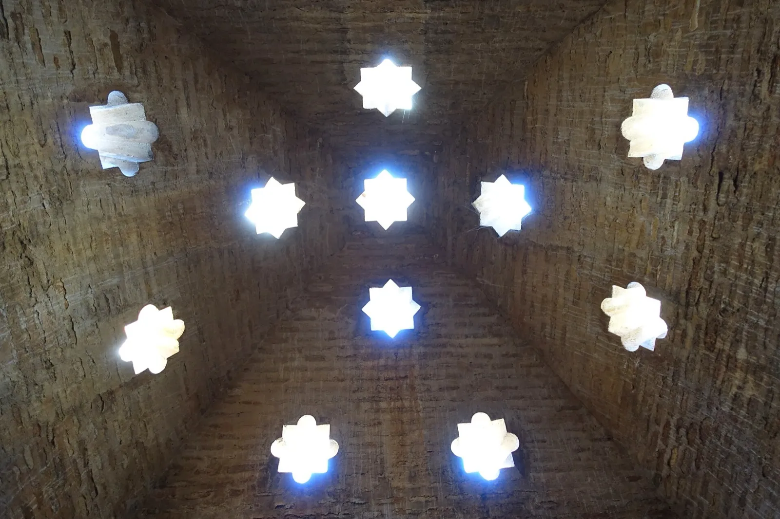 Abóbada de tijolo dos banhos de Comares, na Alhambra, com claraboias em forma de estrela de oito pontas