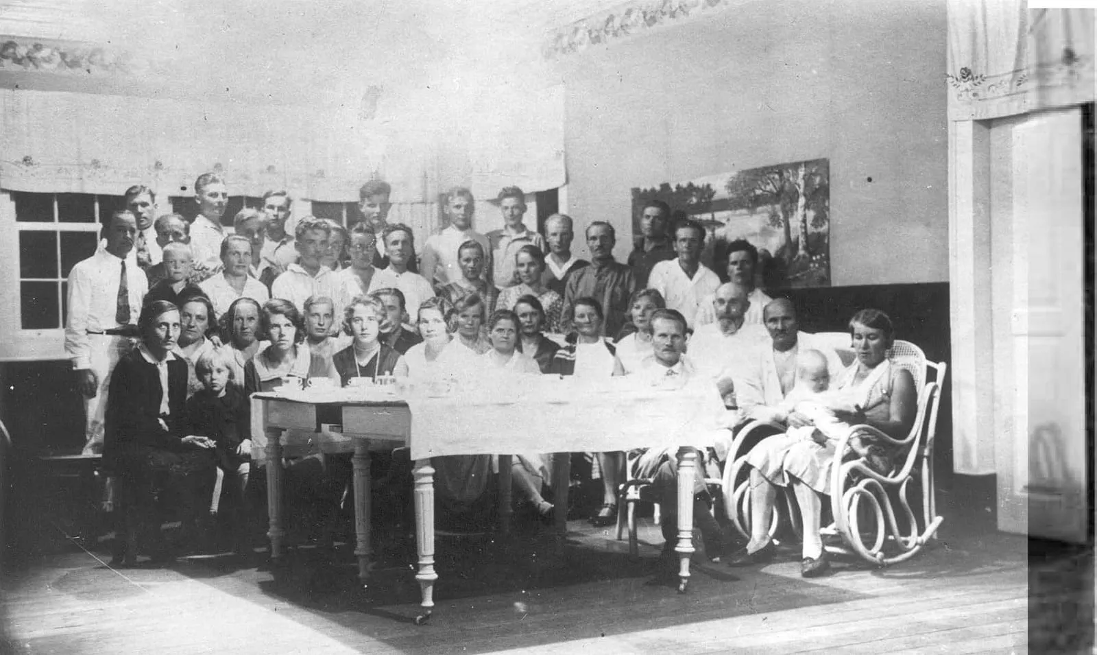 Fotografia em preto e branco de 1929 com dezenas de colonos finlandeses reunidos no andar de cima do casarão da fazenda de Penedo