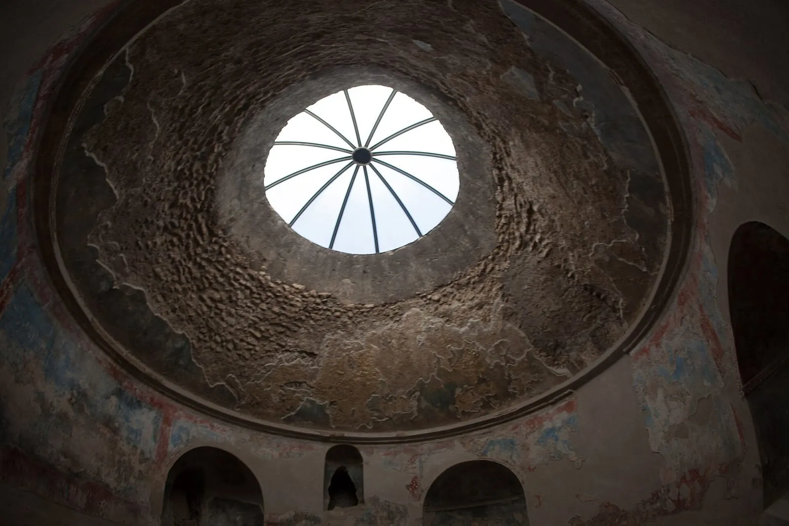 Sala abobadada das Termas Estabianas, em Pompeia, com óculo no teto, nichos nas paredes e restos de estuque pintado