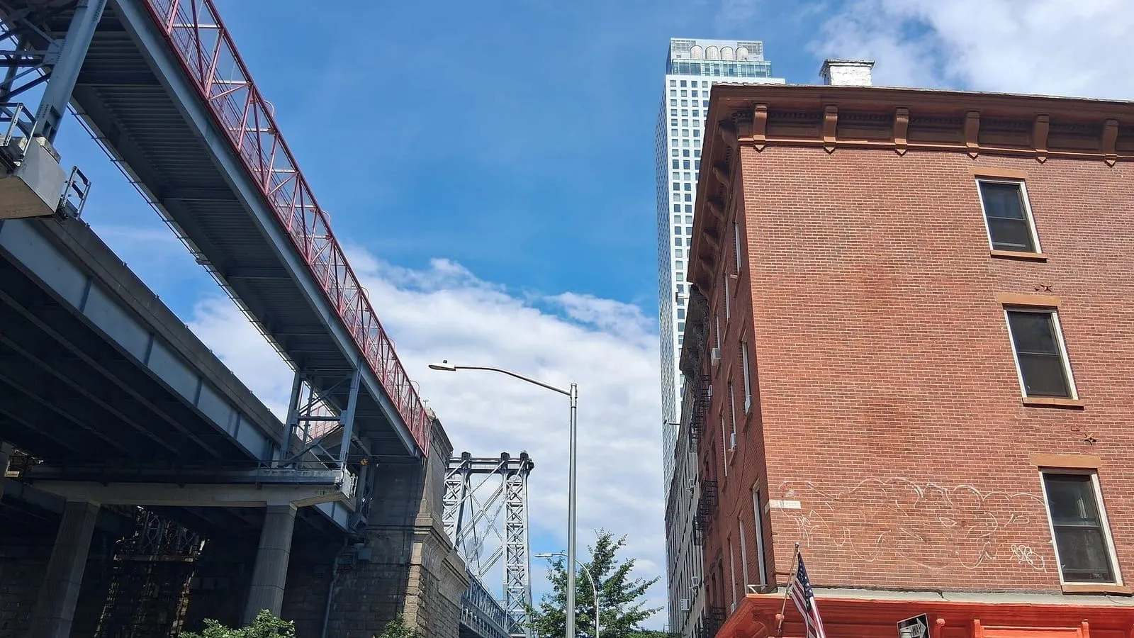 Rua de Williamsburg, no Brooklyn, com a ponte Williamsburg ao fundo e prédios de tijolo